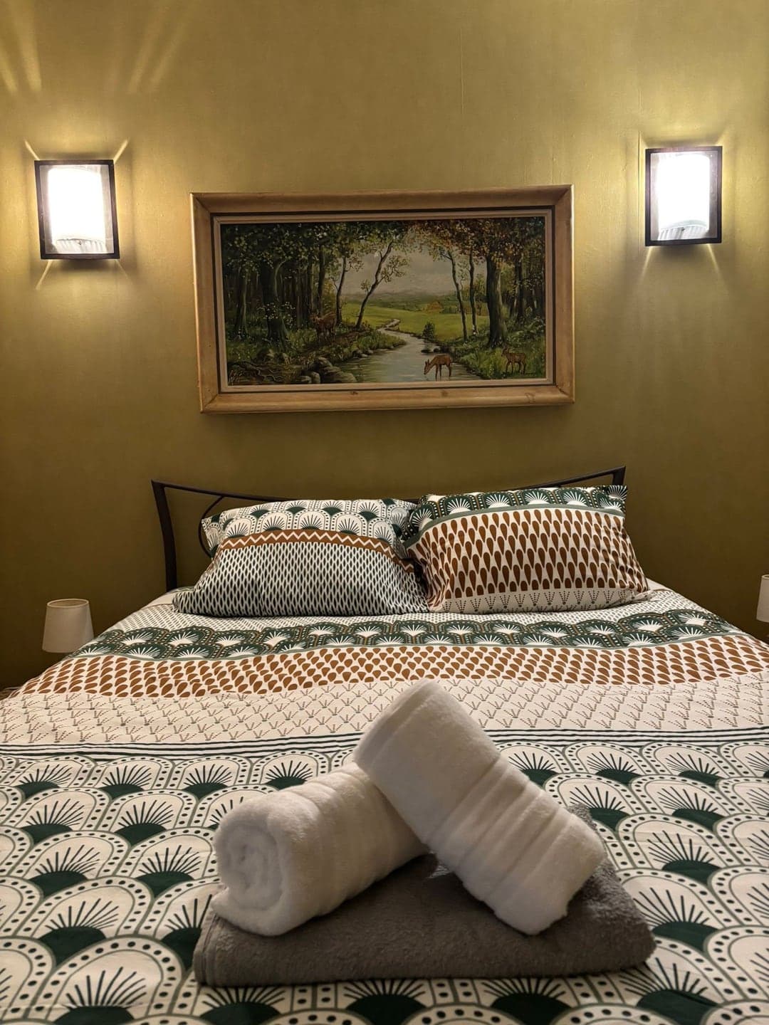 Chambre préparée avec linge propre et serviettes roulées